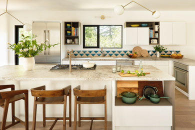 Kitchen - transitional brown floor kitchen idea in San Francisco with a drop-in sink, flat-panel cabinets, white cabinets, multicolored backsplash, stainless steel appliances and multicolored countertops