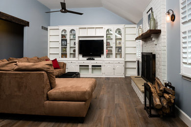 Design ideas for a mid-sized transitional enclosed family room in Philadelphia with grey walls, dark hardwood floors, a standard fireplace, a brick fireplace surround, a built-in media wall and brown floor.
