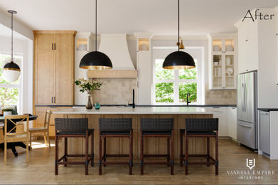 Klassisk inredning av ett mellanstort svart svart kök, med en undermonterad diskho, luckor med upphöjd panel, skåp i ljust trä, marmorbänkskiva, beige stänkskydd, stänkskydd i keramik, rostfria vitvaror, mellanmörkt trägolv, en köksö och brunt golv