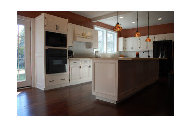 Photo of a traditional l-shaped eat-in kitchen in Columbus with raised-panel cabinets and white cabinets.