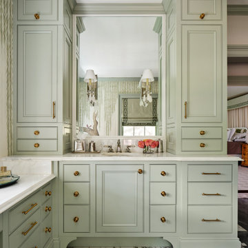 Soft green vanity cabinets in a luxurious primary bath
