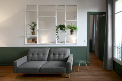 Aménagement d'un salon contemporain avec un mur vert et un sol en bois brun.