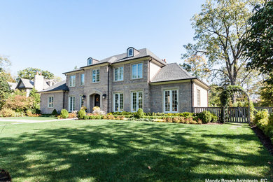 Example of a huge classic two-story mixed siding house exterior design in Chicago with a hip roof and a shingle roof