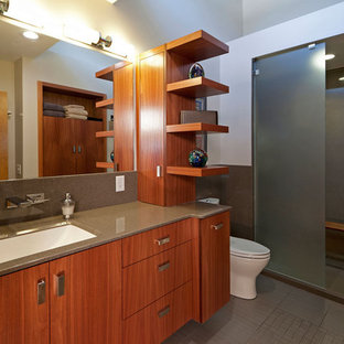 Inspiration pour une salle de bain principale minimaliste de taille moyenne avec des carreaux de céramique, une douche ouverte, un placard à porte plane, des portes de placard en bois brun, un WC à poser, un carrelage gris, un mur blanc, un sol en carrelage de porcelaine, un plan de toilette en onyx, un lavabo encastré et aucune cabine.