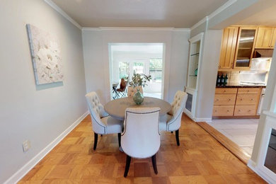 Mid-century modern medium tone wood floor dining room photo in Oklahoma City with gray walls