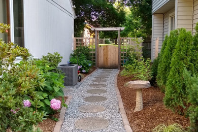 Design ideas for a small traditional partial sun side yard concrete paver and wood fence landscaping in Other.