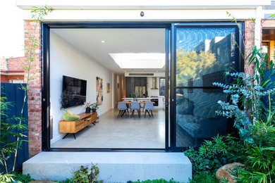Great room - large contemporary concrete floor great room idea in Melbourne with white walls and no fireplace