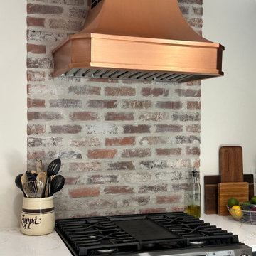 Copper Range Hood: Blending Rustic Brick Charm in Kitchen