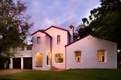 Diseño de fachada de casa blanca y roja mediterránea de dos plantas con revestimiento de estuco y tejado de teja de barro
