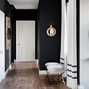 Idéer för att renovera en mellanstor vintage hall, med svarta väggar och mellanmörkt trägolv
