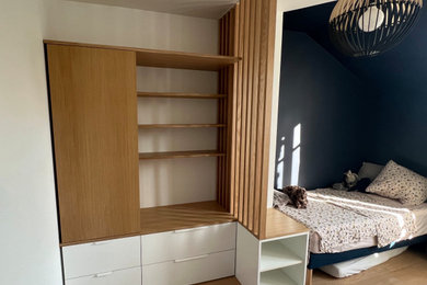Foto de dormitorio infantil de 4 a 10 años contemporáneo de tamaño medio con paredes azules, suelo de madera clara y suelo marrón
