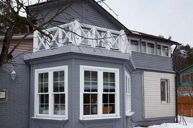 This is an example of a scandinavian two-storey grey exterior in Moscow with a gable roof and mixed siding.
