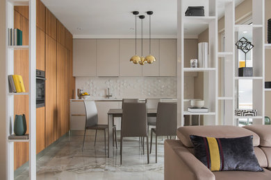 Mid-sized contemporary l-shaped eat-in kitchen in Moscow with an undermount sink, flat-panel cabinets, beige cabinets, quartz benchtops, white splashback, porcelain splashback, black appliances, porcelain floors, beige floor and white benchtop.