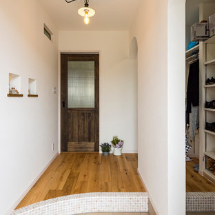 他の地域のカントリー風おしゃれな玄関 (白い壁、セラミックタイルの床、ベージュの床) の写真