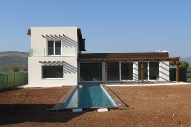 Imagen de fachada blanca mediterránea de tamaño medio de dos plantas con revestimientos combinados y tejado plano