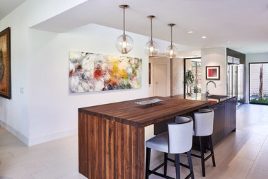 Inspiration for a mid-sized contemporary galley eat-in kitchen in Houston with a single-bowl sink, flat-panel cabinets, dark wood cabinets, wood benchtops, ceramic floors and with island.