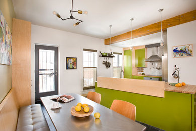 Inspiration for a small industrial u-shaped slate floor eat-in kitchen remodel in Boston with flat-panel cabinets, green cabinets, wood countertops, white backsplash, stone tile backsplash, stainless steel appliances and a peninsula