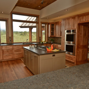 Large rustic kitchen pantry ideas - Inspiration for a large rustic l-shaped medium tone wood floor kitchen pantry remodel in Albuquerque with an undermount sink, raised-panel cabinets, medium tone wood cabinets, quartzite countertops, stone tile backsplash, stainless steel appliances and an island