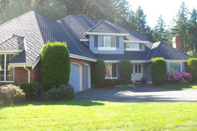 Imagen de fachada de casa beige tradicional grande de dos plantas con tejado a cuatro aguas y tejado de teja de madera