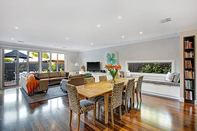 This is an example of a modern family room in Melbourne with grey walls and dark hardwood floors.
