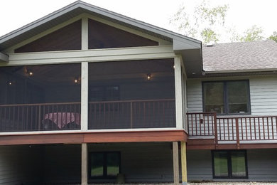 Mid-sized elegant screened-in side porch photo in Chicago with decking and a roof extension