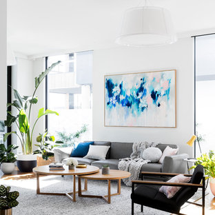 Inspiration för ett funkis allrum med öppen planlösning, med vita väggar, mellanmörkt trägolv, brunt golv, en dubbelsidig öppen spis, en spiselkrans i sten och en väggmonterad TV