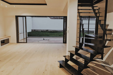 Diseño de escalera en L minimalista grande sin contrahuella con escalones de metal