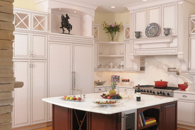 Inspiration for a large timeless u-shaped medium tone wood floor open concept kitchen remodel in Denver with raised-panel cabinets, marble countertops, an island, white cabinets, white backsplash, stone slab backsplash and stainless steel appliances