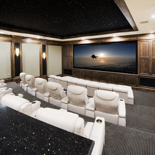 This is an example of an expansive classic enclosed home cinema in Austin with beige walls, carpet, a projector screen and multi-coloured floors.
