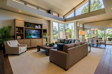 Example of a transitional open concept medium tone wood floor and brown floor living room design in Portland with beige walls and a tv stand