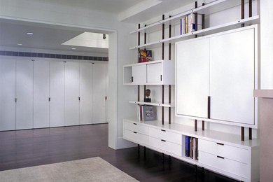 Inspiration for a mid-sized modern formal and open concept dark wood floor and brown floor living room remodel in New York with white walls, no fireplace and a media wall