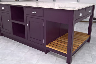 Elegant eat-in kitchen photo in Dorset with purple cabinets, granite countertops and an island
