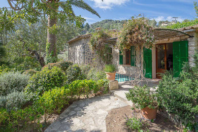 Imagen de acceso privado rústico grande en verano en patio con exposición parcial al sol y adoquines de piedra natural