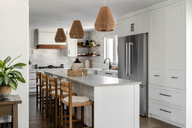 Eat-in kitchen - mid-sized cottage l-shaped dark wood floor and brown floor eat-in kitchen idea in Toronto with an undermount sink, shaker cabinets, white cabinets, quartz countertops, white backsplash, subway tile backsplash, stainless steel appliances, two islands and gray countertops
