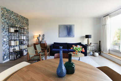 Cette photo montre un salon tendance de taille moyenne et fermé avec une salle de réception, un mur blanc, parquet clair, aucune cheminée et un sol marron.