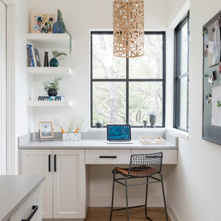 Foto på ett lantligt hemmabibliotek, med gula väggar, ljust trägolv, ett inbyggt skrivbord och beiget golv