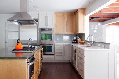 Large trendy l-shaped dark wood floor open concept kitchen photo in Nashville with a double-bowl sink, shaker cabinets, light wood cabinets, quartzite countertops, gray backsplash, glass tile backsplash, stainless steel appliances and an island