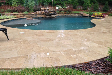 Ejemplo de piscina con fuente natural de estilo americano de tamaño medio a medida en patio trasero con adoquines de piedra natural