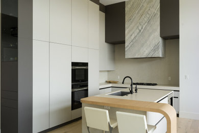 Inspiration for a huge contemporary l-shaped light wood floor eat-in kitchen remodel in Vancouver with an undermount sink, flat-panel cabinets, gray cabinets, quartz countertops, gray backsplash, quartz backsplash, paneled appliances and an island