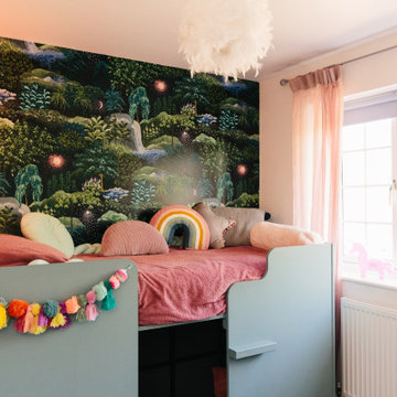 An eclectic children's bedroom with pops of pink and nature inspired wallpaper