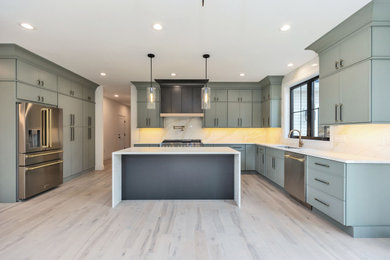 Open concept kitchen - large transitional u-shaped light wood floor and beige floor open concept kitchen idea in Boston with an undermount sink, shaker cabinets, green cabinets, quartz countertops, white backsplash, quartz backsplash, stainless steel appliances, an island and white countertops