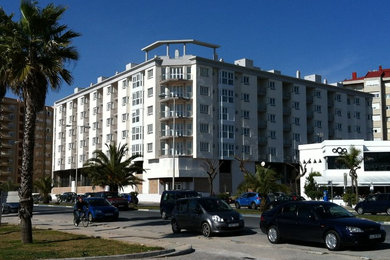 Modelo de fachada blanca grande de tres plantas con revestimientos combinados y tejado plano