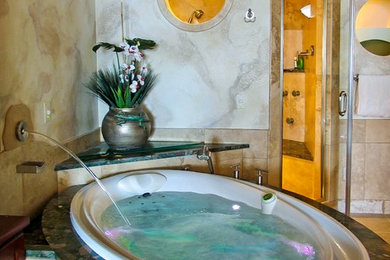 Large tuscan master beige tile and marble tile marble floor and beige floor bathroom photo with beige walls, recessed-panel cabinets, medium tone wood cabinets, granite countertops, a hinged shower door and an undermount sink