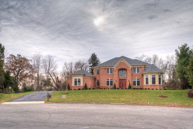Example of a mid-sized classic red two-story brick exterior home design in DC Metro with a shingle roof