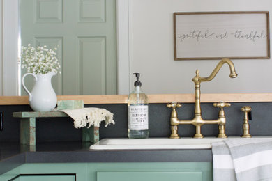 Country l-shaped eat-in kitchen photo in Los Angeles with a drop-in sink, recessed-panel cabinets, green cabinets, black backsplash and black countertops