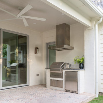 Outdoor kitchen with built-in grill and stainless hood