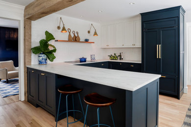 Eat-in kitchen - small transitional u-shaped marble floor, beige floor and exposed beam eat-in kitchen idea in New York with a farmhouse sink, shaker cabinets, blue cabinets, marble countertops, white backsplash, ceramic backsplash, paneled appliances, no island and white countertops