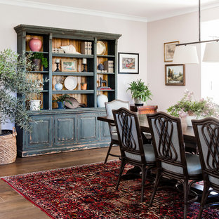 Réalisation d'une grande salle à manger tradition fermée avec un mur rose, un sol en bois foncé et un sol marron.