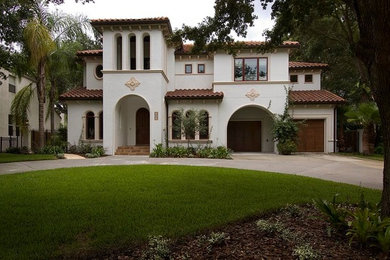 Mediterranean white two-story stucco exterior home idea in Tampa with a hip roof