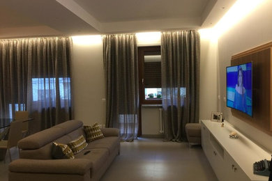 Idee per un soggiorno minimal di medie dimensioni e aperto con pavimento in gres porcellanato, TV a parete, pavimento grigio e pareti grigie